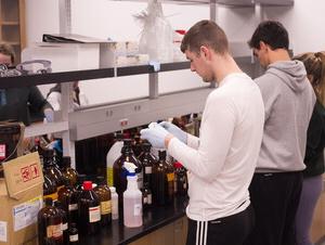 Students unpack items in a biology lab.